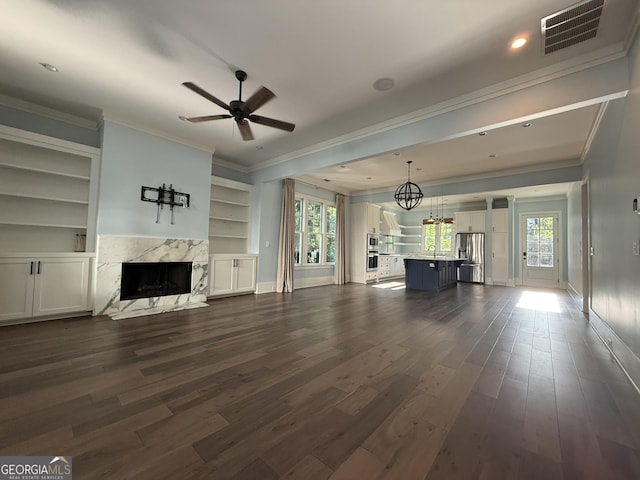10583 Serenbe Ln, Palmetto, GA 30268 - unfurnished living room with crown molding, a high end fireplace, dark wood finished floors, ceiling fan, and built in features