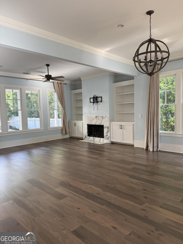10583 Serenbe Ln, Palmetto, GA 30268 - unfurnished living room with ornamental molding, a chandelier, dark wood-style floors, a fireplace, and plenty of natural light