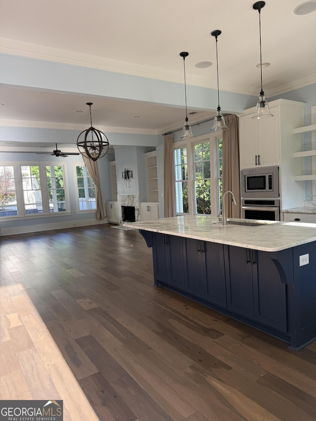 10583 Serenbe Ln, Palmetto, GA 30268 - kitchen featuring stainless steel appliances, crown molding, a high end fireplace, open floor plan, and white cabinetry