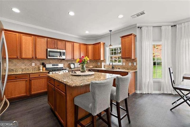 214 Crestmont Way, Canton, GA 30114 - kitchen with appliances with stainless steel finishes, brown cabinets, a sink, a breakfast bar area, and recessed lighting