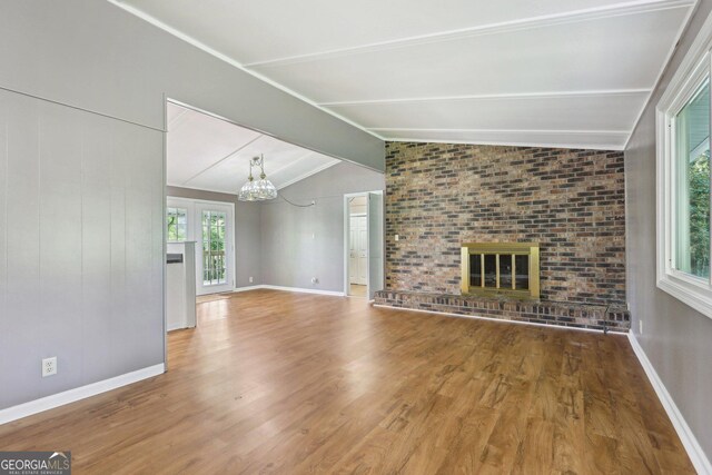54 Owl Ct, Monticello, GA 31064 - unfurnished living room featuring a chandelier, a fireplace, wood finished floors, and baseboards
