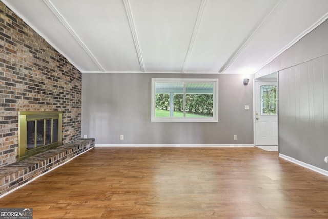 54 Owl Ct, Monticello, GA 31064 - unfurnished living room featuring wood finished floors, lofted ceiling, and a brick fireplace
