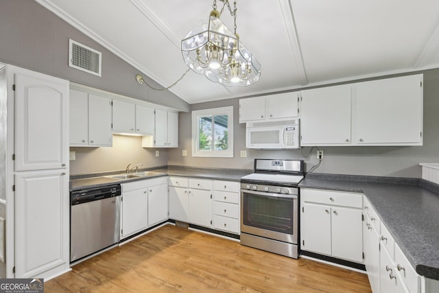 54 Owl Ct, Monticello, GA 31064 - kitchen featuring stainless steel appliances, lofted ceiling, dark countertops, a sink, and a chandelier