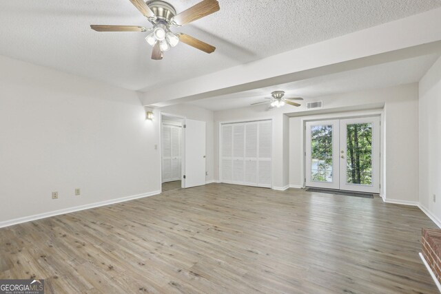54 Owl Ct, Monticello, GA 31064 - unfurnished living room featuring wood finished floors, baseboards, a ceiling fan, a textured ceiling, and french doors