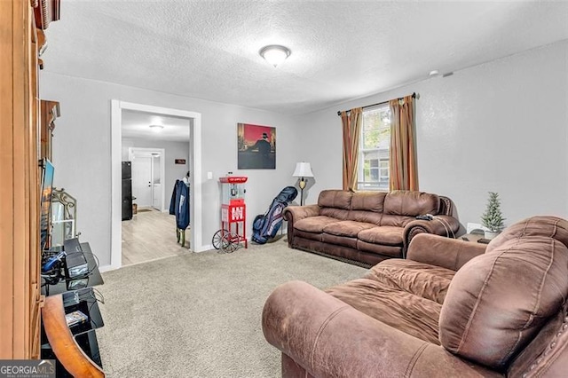living room featuring light colored carpet, a textured ceiling, and baseboards