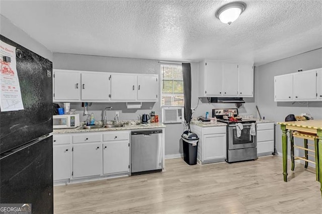 kitchen featuring appliances with stainless steel finishes, a sink, a textured ceiling, white cabinetry, and light countertops
