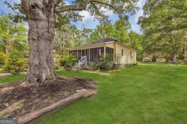 view of side of home featuring a sunroom and a yard