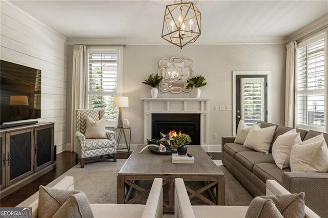 3000 Haven Mill Ln, Milton, GA 30004 - living room featuring a chandelier, ornamental molding, a warm lit fireplace, wood finished floors, and wood walls
