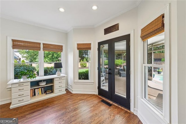 entryway featuring french doors, ornamental molding, wood finished floors, healthy amount of natural light, and recessed lighting