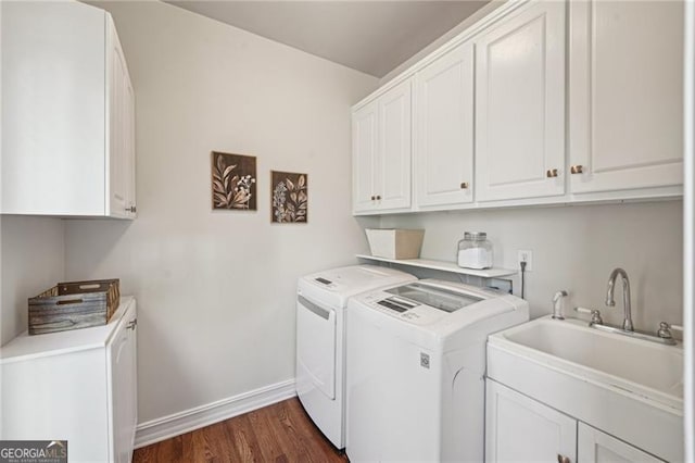 clothes washing area featuring independent washer and dryer, cabinet space, dark wood-style floors, and baseboards