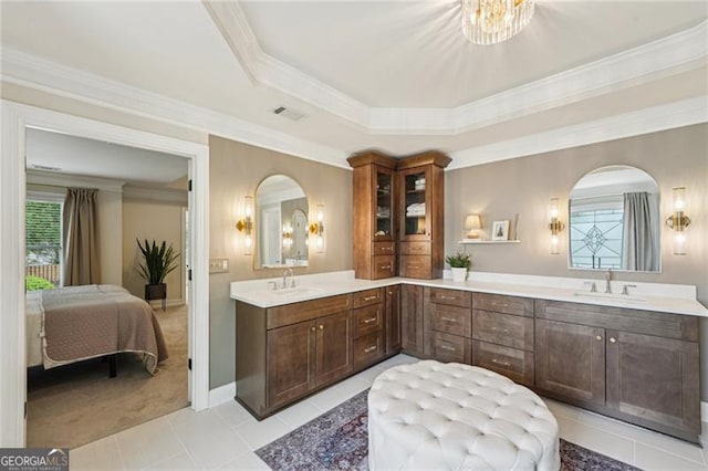 bathroom featuring double vanity, connected bathroom, crown molding, tile patterned flooring, and baseboards