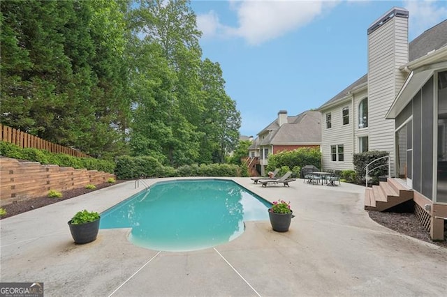view of swimming pool featuring a patio area and fence