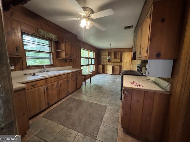 4720 Ben Hill Rd, South Fulton, GA 30349 - kitchen featuring tile countertops, a sink, a ceiling fan, wood walls, and brown cabinetry