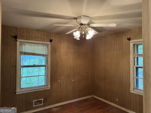 4720 Ben Hill Rd, South Fulton, GA 30349 - spare room featuring dark wood-style flooring, a ceiling fan, wooden walls, and baseboards