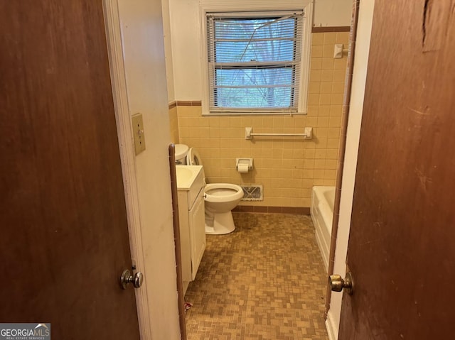4720 Ben Hill Rd, South Fulton, GA 30349 - full bathroom with tile walls, vanity, a tub, wainscoting, and toilet