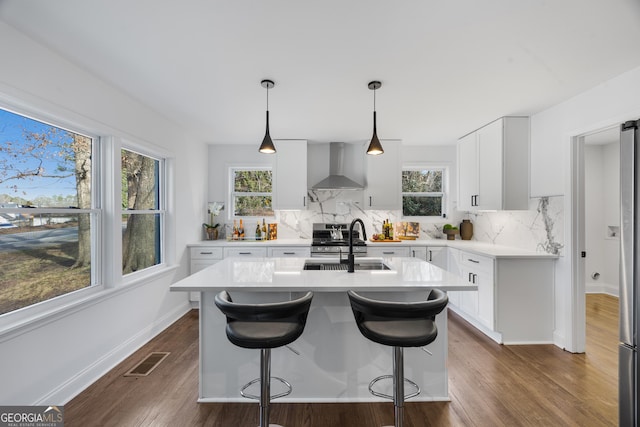 1870 Avon Ave SW, Atlanta, GA 30311 - kitchen with wall chimney range hood, tasteful backsplash, light countertops, dark wood finished floors, and a kitchen bar