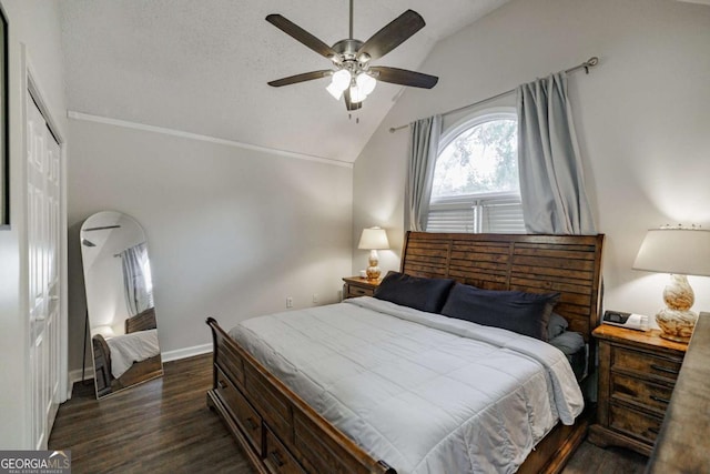 bedroom with vaulted ceiling, dark wood-style floors, a closet, baseboards, and a ceiling fan