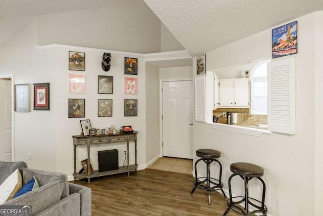 living room with lofted ceiling, wood finished floors, and baseboards