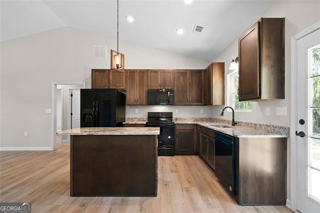 389 Campground School Rd, Dallas, GA 30157 - kitchen with black appliances, a sink, a center island, light stone countertops, and light wood-style floors