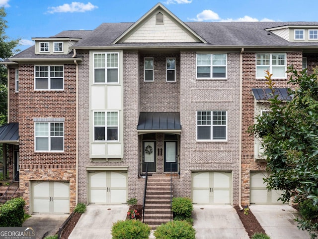 townhome / multi-family property featuring brick siding, driveway, and a garage