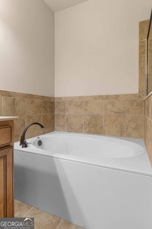 full bathroom featuring vanity, a garden tub, and tile patterned floors