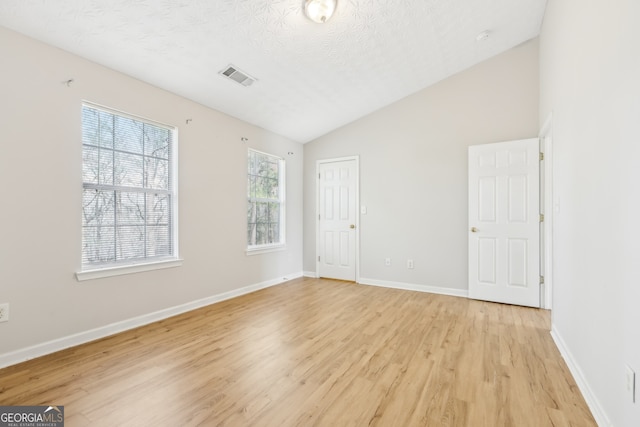 103 Timber Ridge Dr, Cartersville, GA 30121 - unfurnished bedroom with vaulted ceiling, light wood-style flooring, a textured ceiling, and baseboards