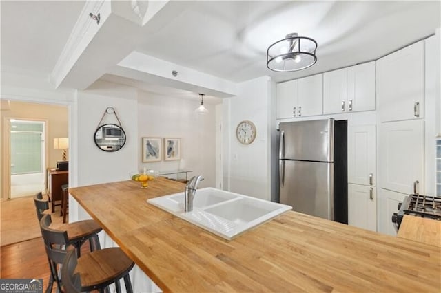 620 Peachtree St NE Unit 403, Atlanta, GA 30308 - kitchen with freestanding refrigerator, a sink, butcher block counters, and white cabinets