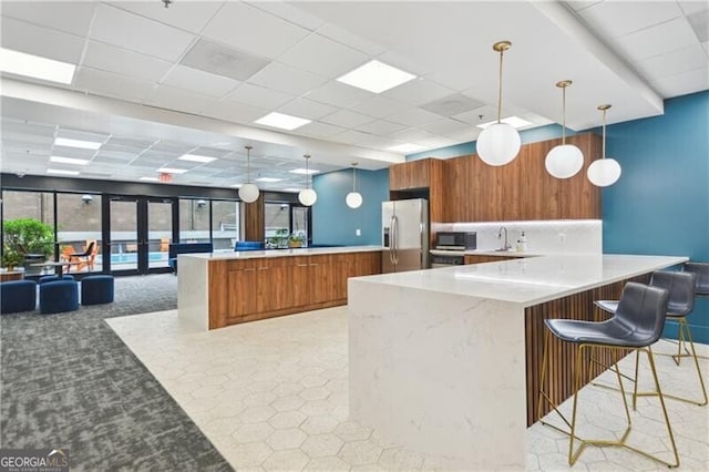 620 Peachtree St NE Unit 403, Atlanta, GA 30308 - kitchen with stainless steel appliances, brown cabinets, a peninsula, a drop ceiling, and modern cabinets
