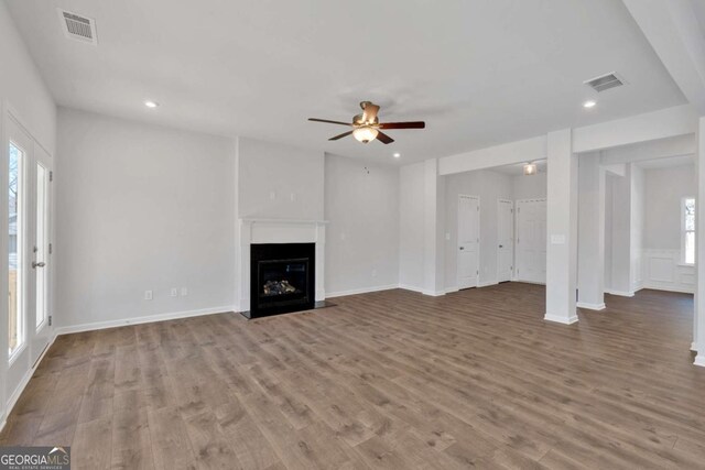 16 Grove Pointe Way SE, Cartersville, GA 30120 - unfurnished living room featuring ceiling fan, healthy amount of natural light, wood finished floors, a fireplace with flush hearth, and recessed lighting