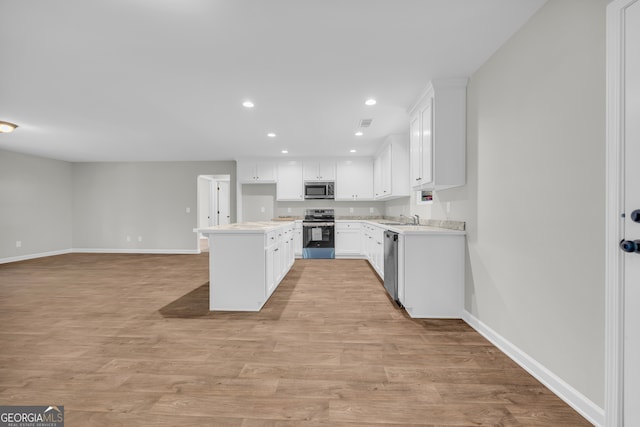 350 Maple St, Hartwell, GA 30643 - kitchen with appliances with stainless steel finishes, recessed lighting, light wood finished floors, and white cabinets