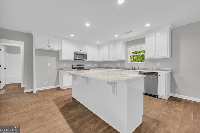 350 Maple St, Hartwell, GA 30643 - kitchen featuring stainless steel appliances, a kitchen island, light countertops, white cabinets, and light wood-type flooring