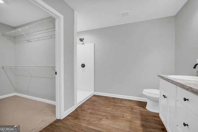350 Maple St, Hartwell, GA 30643 - full bath featuring a walk in shower, vanity, a walk in closet, and wood finished floors