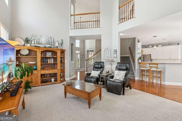 1316 Wind Chime Ct, Lawrenceville, GA 30045 - living area featuring carpet, stairway, a towering ceiling, and baseboards