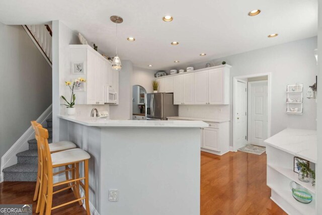 1316 Wind Chime Ct, Lawrenceville, GA 30045 - kitchen featuring stainless steel fridge, open shelves, white microwave, a peninsula, and recessed lighting