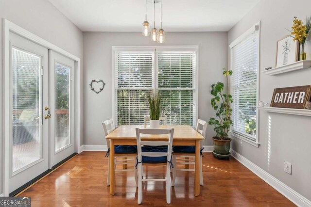 1316 Wind Chime Ct, Lawrenceville, GA 30045 - dining space with healthy amount of natural light, wood finished floors, baseboards, and french doors