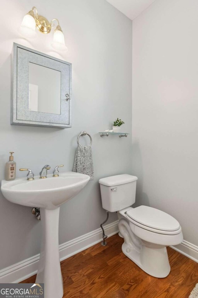 1316 Wind Chime Ct, Lawrenceville, GA 30045 - half bath featuring toilet, baseboards, and wood finished floors