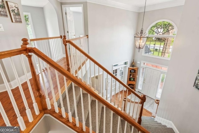 1316 Wind Chime Ct, Lawrenceville, GA 30045 - staircase with a chandelier, baseboards, ornamental molding, and wood finished floors