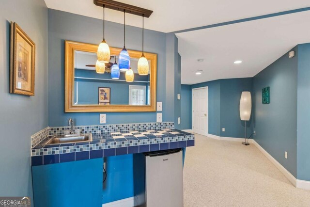 1316 Wind Chime Ct, Lawrenceville, GA 30045 - kitchen with tile counters, a sink, carpet floors, pendant lighting, and baseboards