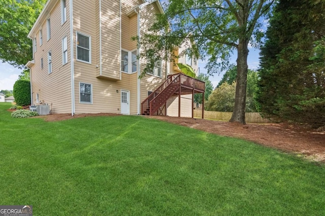 1316 Wind Chime Ct, Lawrenceville, GA 30045 - rear view of house with a wooden deck, stairway, a garage, a lawn, and central AC unit