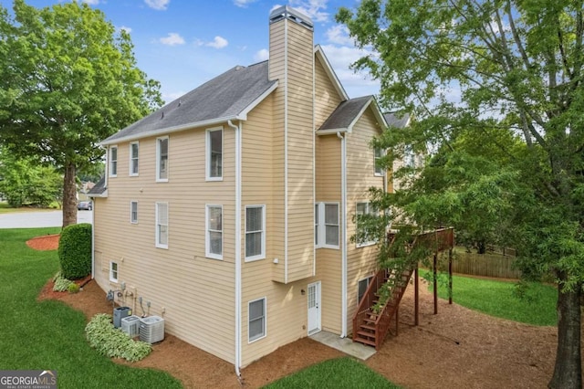 1316 Wind Chime Ct, Lawrenceville, GA 30045 - rear view of house with stairway, a chimney, central air condition unit, and a shingled roof