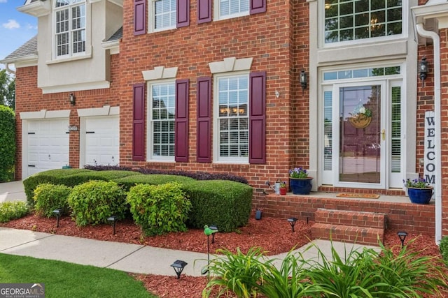 1316 Wind Chime Ct, Lawrenceville, GA 30045 - view of exterior entry featuring brick siding and a garage