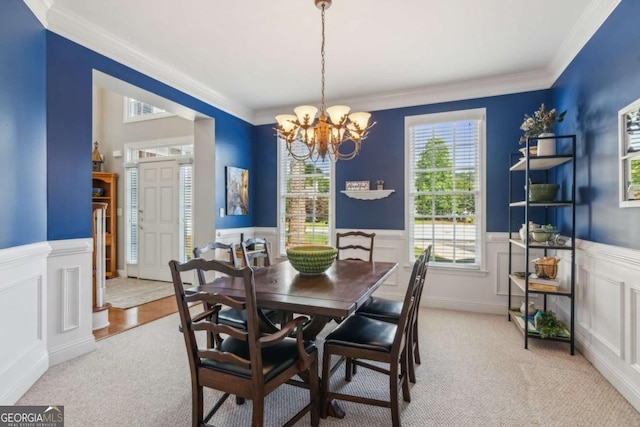 1316 Wind Chime Ct, Lawrenceville, GA 30045 - dining space featuring a chandelier, healthy amount of natural light, light colored carpet, ornamental molding, and wainscoting