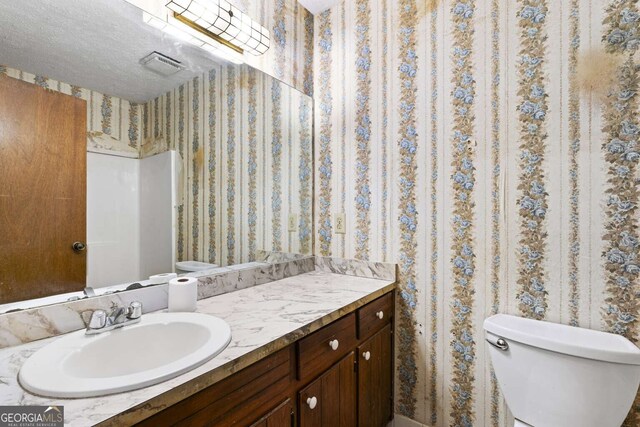 1909 Winding Creek Ln SW, Marietta, GA 30064 - bathroom with wallpapered walls, toilet, and vanity