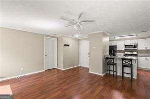 1371 Keys Lake Dr NE, Atlanta, GA 30319 - unfurnished living room with wood finished floors, baseboards, and ceiling fan