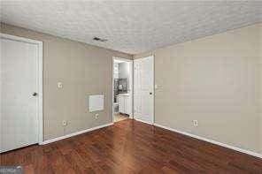 1371 Keys Lake Dr NE, Atlanta, GA 30319 - unfurnished bedroom with baseboards and wood finished floors