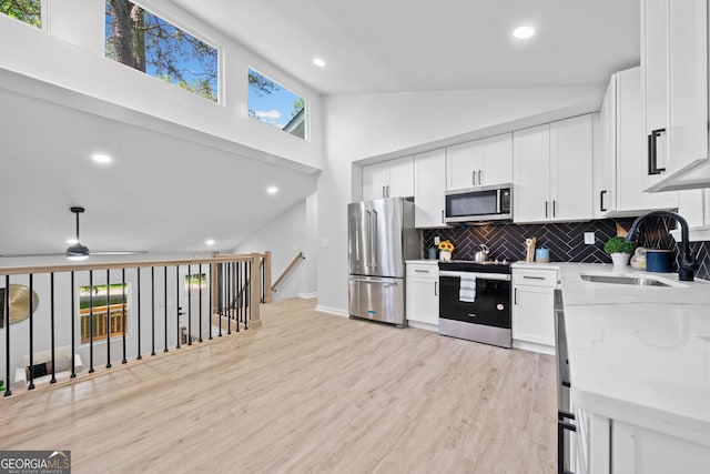 4058 Daron Ct, Ellenwood, GA 30294 - kitchen featuring appliances with stainless steel finishes, a sink, decorative backsplash, light wood-type flooring, and white cabinetry