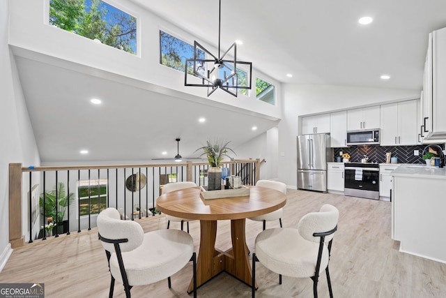 4058 Daron Ct, Ellenwood, GA 30294 - dining room with light wood-style flooring, high vaulted ceiling, a chandelier, recessed lighting, and a ceiling fan