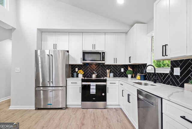 4058 Daron Ct, Ellenwood, GA 30294 - kitchen featuring stainless steel appliances, a sink, light wood finished floors, white cabinets, and decorative backsplash