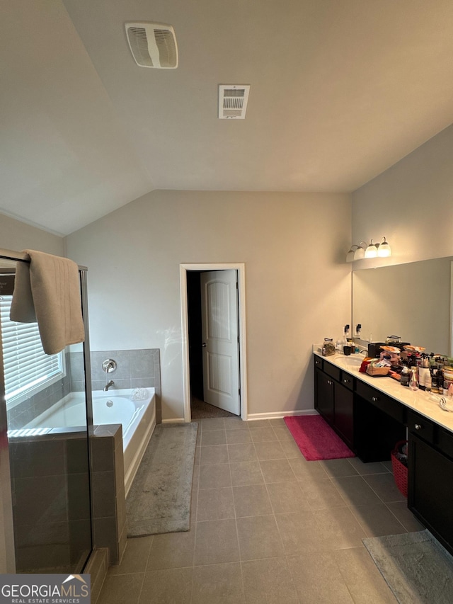 419 Woodmill Way SW, South Fulton, GA 30331 - bathroom featuring a bath, vaulted ceiling, vanity, baseboards, and tile patterned floors
