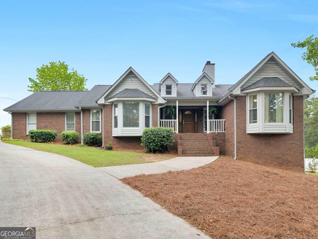 8117 Spivey Rd, Jonesboro, GA 30236 - view of front of house featuring brick siding, covered porch, a chimney, and a front yard